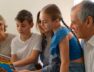 vista-lateral-familia-leyendo-comics-juntos_23-2150503188